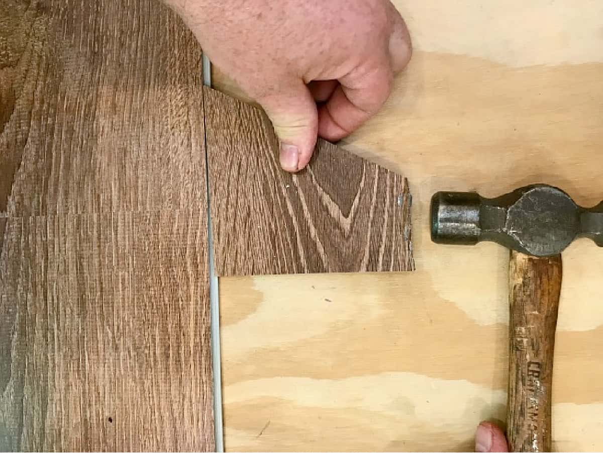 using a hammer to install vinyl plank floor