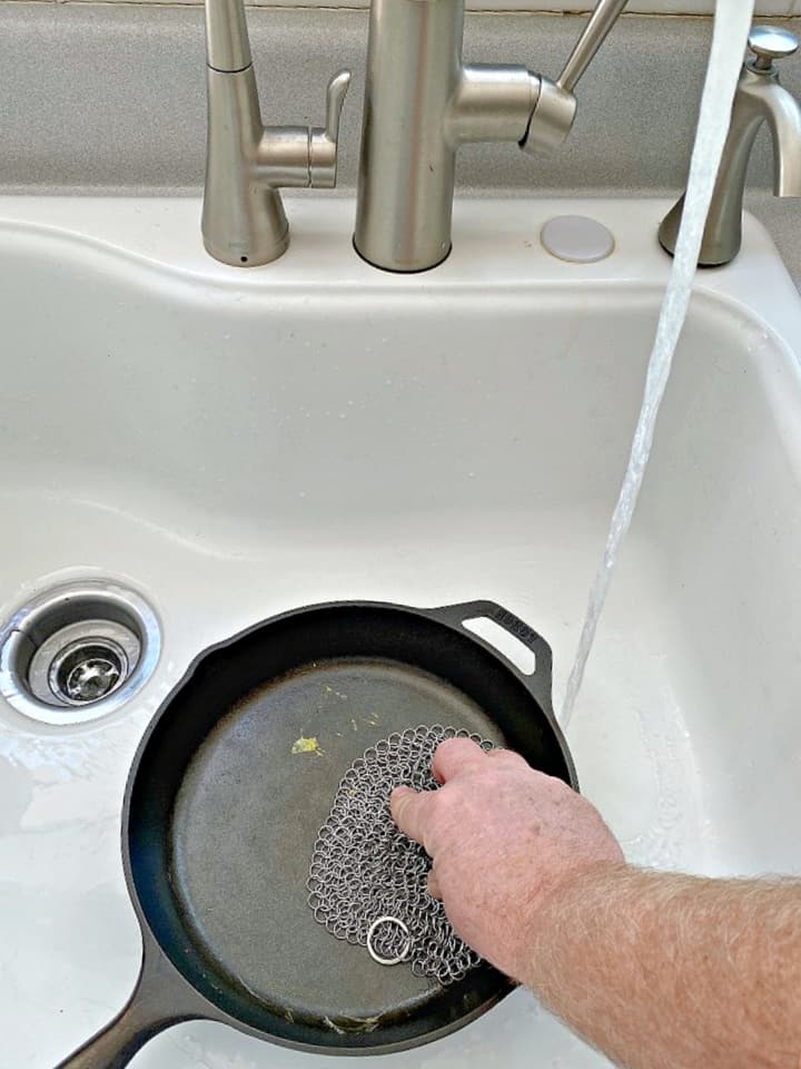 cleaning a cast iron skillet in the sink